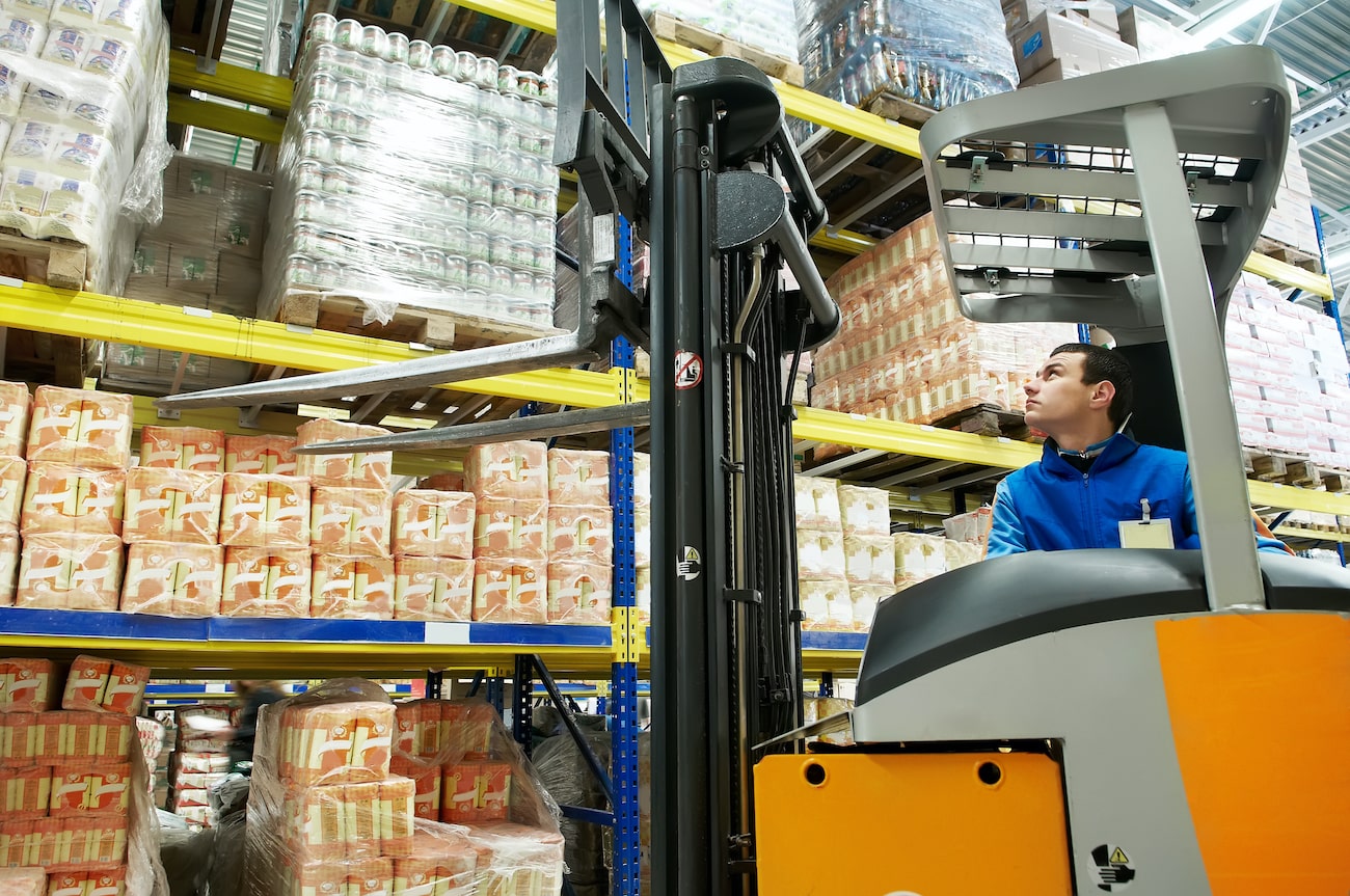 Food-grade warehouse worker operating forklift