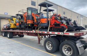 Flatbed load carrying large construction equipment. 